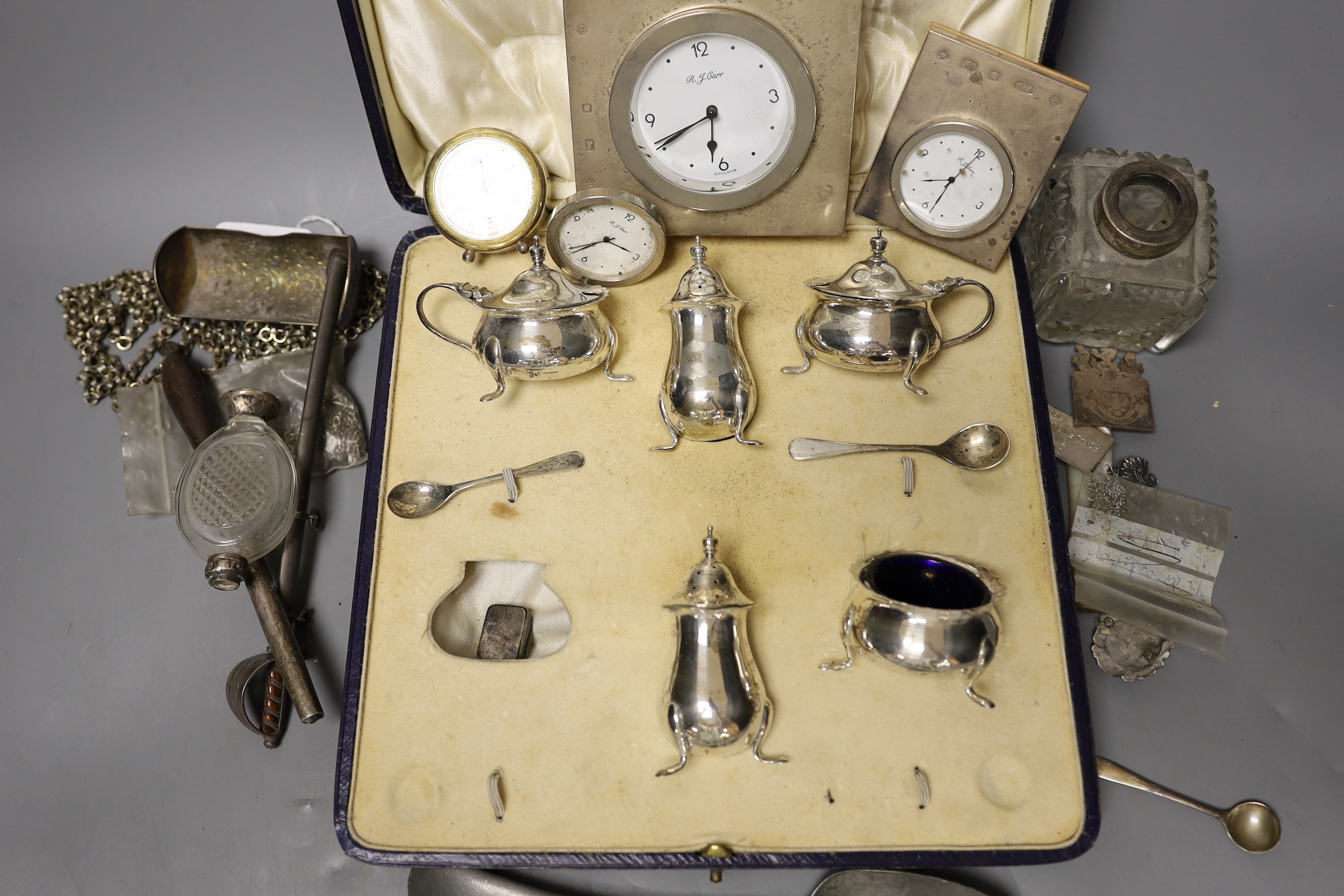 Sundry small silver including a cased part condiment set, three modern silver mounted desk timepieces and a Georgian vinaigrette and thirteen other items including pewter flatware etc.
